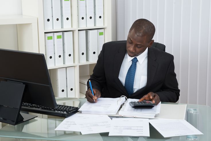 Professionnel africain au travail sur des documents comptables
